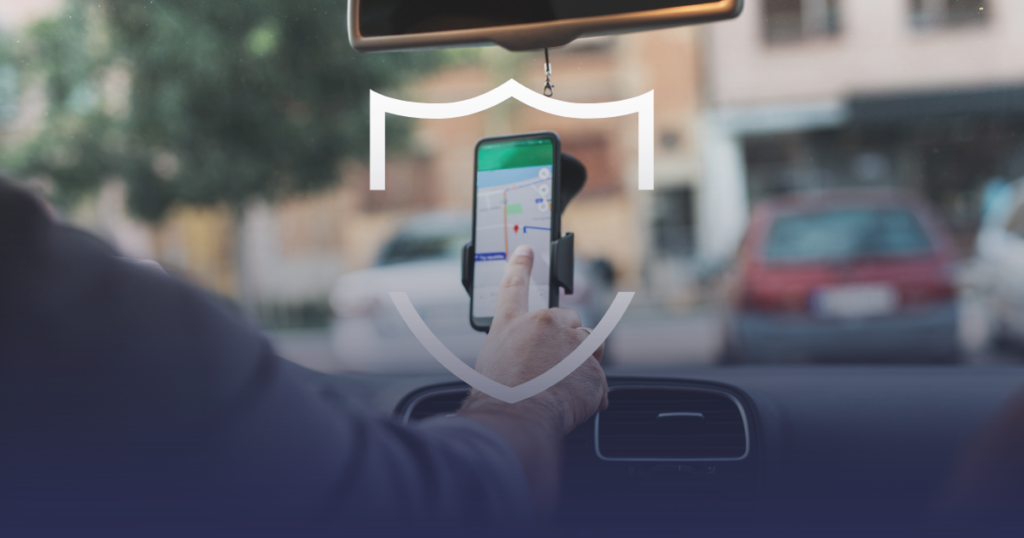 Mão configurando rota no celular com símbolo de segurança, destacando dicas de segurança para motoristas de app.