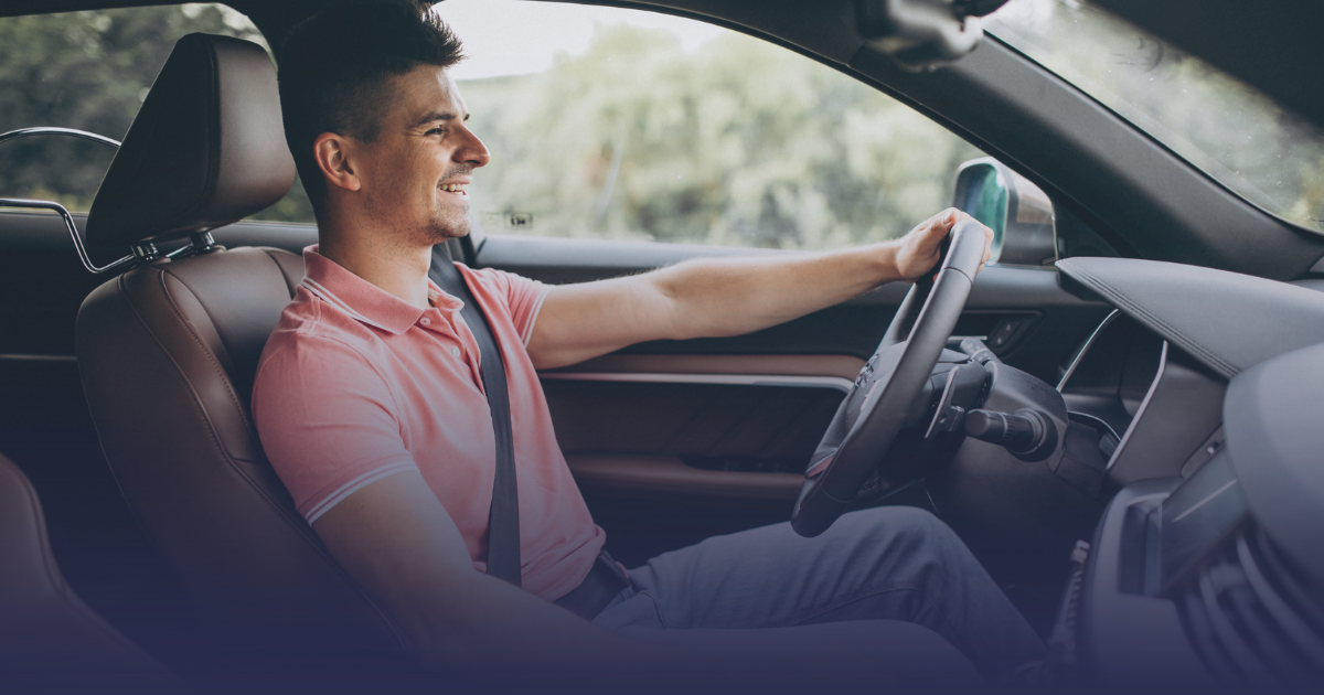 Motorista sorrindo enquanto dirige com eficiência, buscando ganhar mais dinheiro dirigindo como motorista de aplicativo.